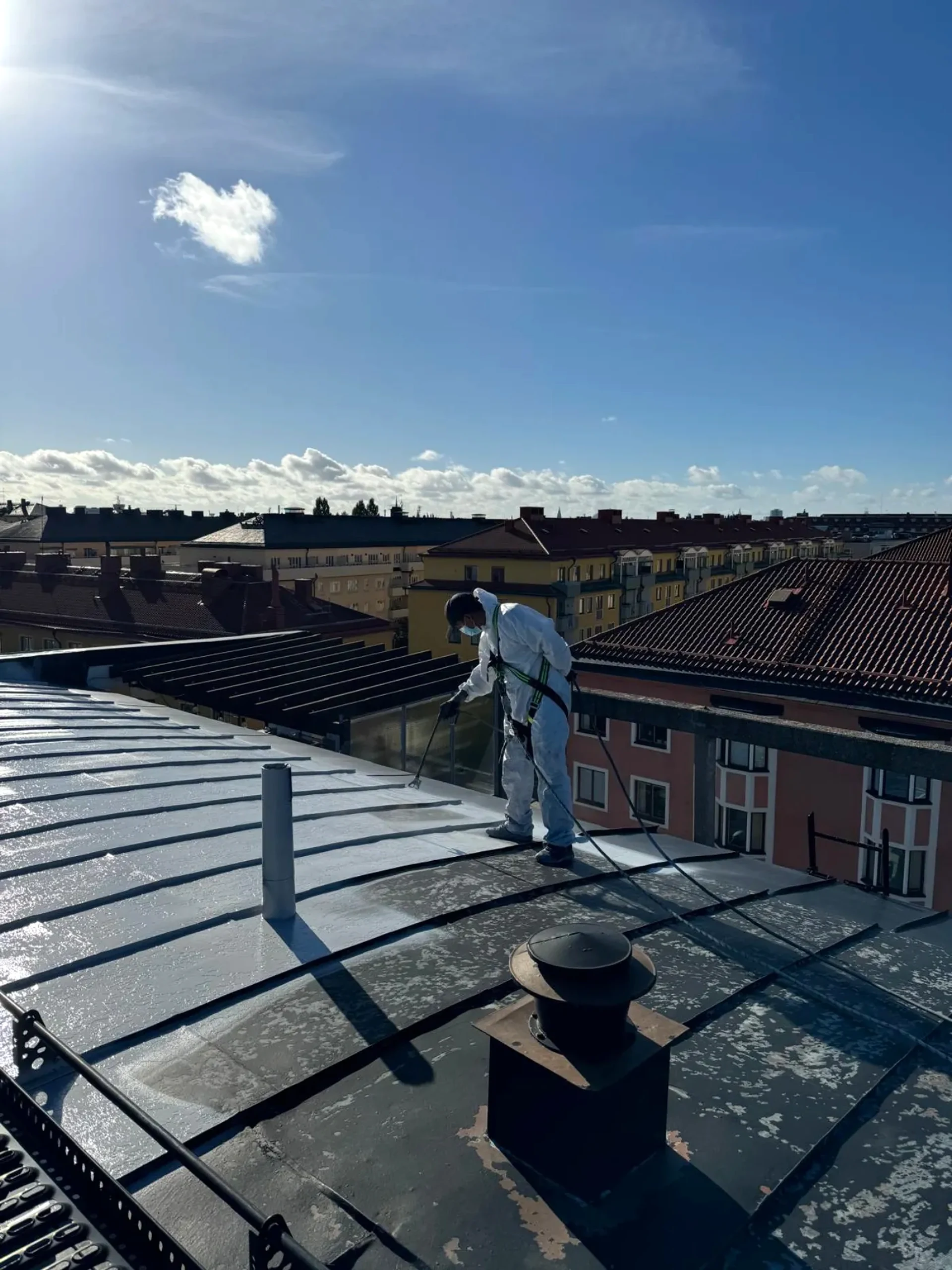 Hantverkare på tak med vy över staden